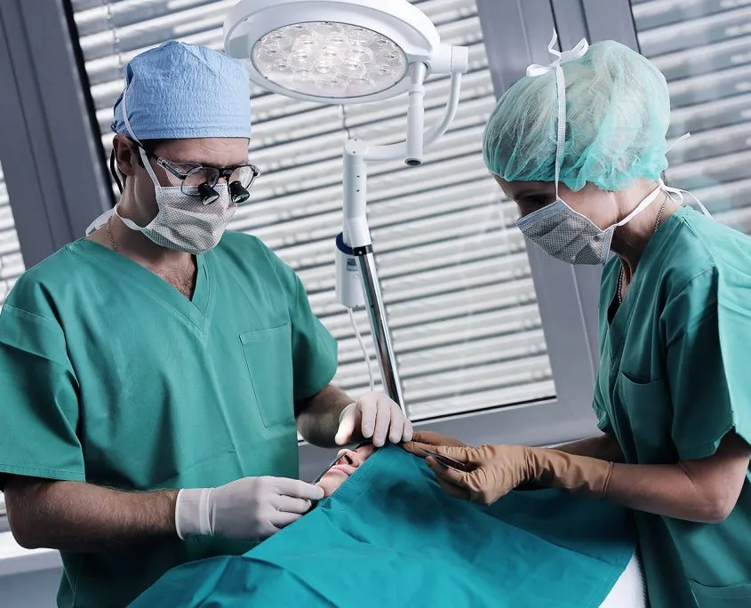 Kirurg in medicinska sestra med posegom v operacijski sobi