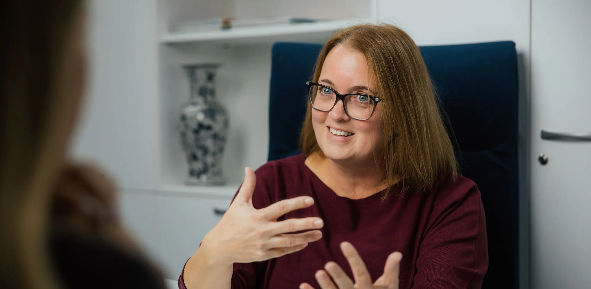 Klinična psihologinja med pogovorom s pacientko v svetli ambulanti